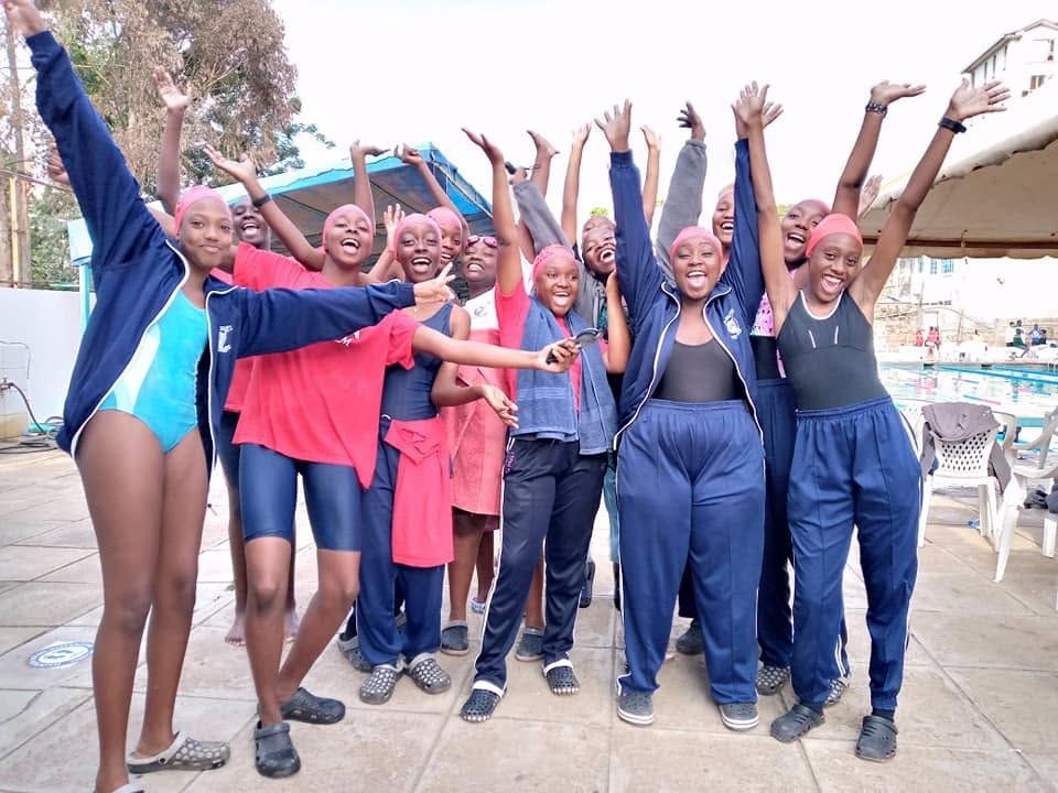 Swimming team members with coaches